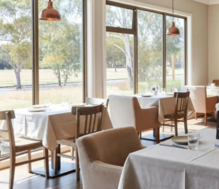 Sunlit Australian bistro interior with wooden tables and a friendly poker game in the background.